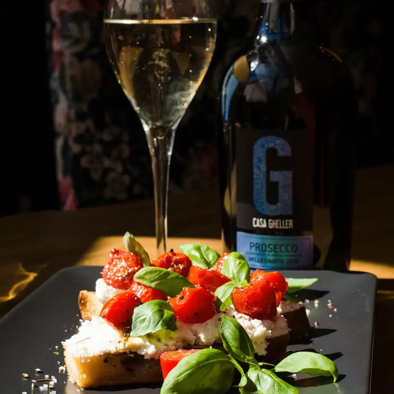 Kieliszek prosecco i bruschetta z pomidorkami i bazylią