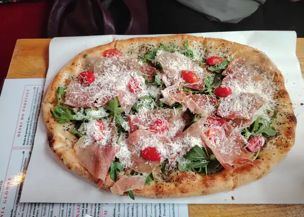 Pizza z prosciutto, rukolą, pomidorkami i parmezanem